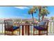 Relaxing condo balcony with seating offers serene waterfront views under the palm trees at 12132 Capri S Cir, Treasure Island, FL 33706