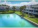 Waterfront condos featuring manicured lawns, palm trees, and private balconies overlooking the picturesque canal at 12132 Capri S Cir, Treasure Island, FL 33706