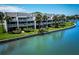 Exterior view of the condo complex featuring waterfront access and lush landscaping at 12132 Capri S Cir, Treasure Island, FL 33706