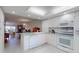 Open concept kitchen with white appliances offering seamless flow into the living area at 12132 Capri S Cir, Treasure Island, FL 33706