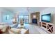 Bright living room featuring a stone fireplace, white furniture, and view of outdoor patio at 12132 Capri S Cir, Treasure Island, FL 33706