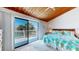Comfortable main bedroom with a vaulted ceiling and large sliding glass door to a private balcony at 12132 Capri S Cir, Treasure Island, FL 33706