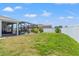 Spacious backyard featuring a green lawn and screened-in porch with view of the swimming pool at 13301 Waterleaf Garden Cir, Riverview, FL 33579