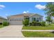 Well-maintained home with a two-car garage, lush landscaping, and manicured front lawn at 13301 Waterleaf Garden Cir, Riverview, FL 33579