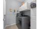 Laundry room featuring gray washer and dryer, gray walls and white cabinets at 13301 Waterleaf Garden Cir, Riverview, FL 33579