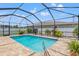 Screened-in pool with brick patio, manicured landscaping, and a backyard view at 13301 Waterleaf Garden Cir, Riverview, FL 33579