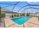 Screened-in pool with brick patio, manicured landscaping, and a backyard view at 13301 Waterleaf Garden Cir, Riverview, FL 33579
