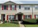 Charming townhouse with a well-maintained lawn, red shutters and matching door at 15733 Stable Run Dr, Spring Hill, FL 34610