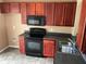 Well-equipped kitchen with sleek black appliances, stained wood cabinetry, and durable countertops at 15733 Stable Run Dr, Spring Hill, FL 34610