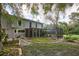 Backyard view showcasing home, screened lanai, and lush landscaped garden with brick-lined flowerbeds at 15917 Dover Cliffe Dr, Lutz, FL 33548