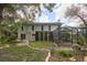 Backyard view showcasing home, screened lanai, and lush landscaped garden with brick-lined flowerbeds at 15917 Dover Cliffe Dr, Lutz, FL 33548