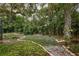 Lush backyard featuring mature trees and landscaping, with a winding brick-lined flowerbed at 15917 Dover Cliffe Dr, Lutz, FL 33548