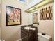 Stylish powder room with vanity, artwork, and decorative accents at 15917 Dover Cliffe Dr, Lutz, FL 33548