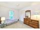 Cozy bedroom featuring neutral carpeting, a window for natural light, and a classic wood dresser with mirror at 15917 Dover Cliffe Dr, Lutz, FL 33548