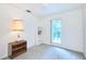 Bright bedroom featuring neutral carpeting, a window providing outdoor views, and minimalist decor at 15917 Dover Cliffe Dr, Lutz, FL 33548