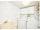 Bright laundry room with washer, dryer, sink, and overhead cabinets for storage at 15917 Dover Cliffe Dr, Lutz, FL 33548