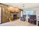 Inviting living area with stone fireplace, comfortable seating, and sliding doors to the outdoors at 15917 Dover Cliffe Dr, Lutz, FL 33548