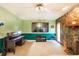 Comfortable living area features a stone fireplace, entertainment center, and green-painted wall at 15917 Dover Cliffe Dr, Lutz, FL 33548