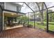 Spacious screened-in patio offering picturesque views of the lush backyard, connecting to additional dining area at 15917 Dover Cliffe Dr, Lutz, FL 33548
