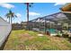 Spacious backyard featuring a screened-in pool and ample green space, perfect for outdoor activities and entertaining at 15925 Marshfield Dr, Tampa, FL 33624