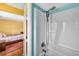 Clean white shower tub with updated fixtures and a view into the adjacent bedroom at 15925 Marshfield Dr, Tampa, FL 33624