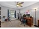Cozy bedroom features a ceiling fan, natural light, and home office set up at 15925 Marshfield Dr, Tampa, FL 33624