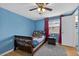 Bedroom with blue walls, wood floors, a ceiling fan, and a dark wood bed with colorful bedding at 15925 Marshfield Dr, Tampa, FL 33624