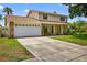 Charming two-story home boasts a well-maintained lawn, attached two-car garage, and inviting facade at 15925 Marshfield Dr, Tampa, FL 33624