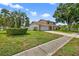 Charming two-story home with a well-manicured lawn, mature trees, and a welcoming entrance at 15925 Marshfield Dr, Tampa, FL 33624