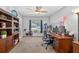 Spacious home office featuring a large desk, bookcase, stationary bike, and treadmill at 15925 Marshfield Dr, Tampa, FL 33624