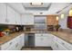 Kitchen with white cabinets, stainless steel dishwasher, and modern pendant lighting at 15925 Marshfield Dr, Tampa, FL 33624