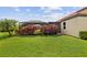 Beautiful backyard featuring lush grass, manicured landscaping, and a screened-in lanai for outdoor enjoyment at 165 Mobbly Bay Dr, Oldsmar, FL 34677