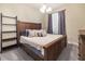 Cozy bedroom with a rustic wood bed frame and soft, neutral-toned decor at 165 Mobbly Bay Dr, Oldsmar, FL 34677
