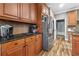 Kitchen area with wood cabinets, granite counters, stainless steel refrigerator, and tile backsplash at 165 Mobbly Bay Dr, Oldsmar, FL 34677