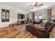 Comfortable living room with a leather sectional sofa, area rug, ceiling fan, and tv at 165 Mobbly Bay Dr, Oldsmar, FL 34677