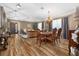 Open-concept living and dining space with wood-look floors, elegant furnishings, and arched doorway at 165 Mobbly Bay Dr, Oldsmar, FL 34677