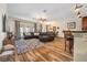 Open-concept living room adjacent to a kitchen with a leather sectional sofa and wood floors at 165 Mobbly Bay Dr, Oldsmar, FL 34677