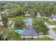 An aerial view of property highlighting backyard pool, lush greenery, and neighborhood at 1711 W Followthru Dr, Tampa, FL 33612