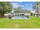 Refreshing backyard pool with a secure fence, surrounded by a lush green lawn, perfect for relaxation and recreation at 1711 W Followthru Dr, Tampa, FL 33612