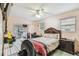 Open bedroom featuring a large bed, tiled floors, a ceiling fan, and a connected den at 1711 W Followthru Dr, Tampa, FL 33612