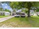 Charming single-story home featuring a well-manicured lawn and mature shade tree in a sunny residential neighborhood at 1711 W Followthru Dr, Tampa, FL 33612