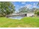 Backyard featuring a swimming pool with a protective fence, surrounded by lush green grass at 1711 W Followthru Dr, Tampa, FL 33612