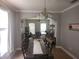 Elegant dining room featuring tile floors, a chandelier, and an arched entrance into a room with a ceiling fan at 1753 Open Field Loop, Brandon, FL 33510