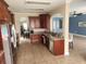 Open concept kitchen with stainless steel appliances, tile floors, and ample counter space, with bar overlooking a living room at 1753 Open Field Loop, Brandon, FL 33510