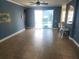 Bright living room with tile flooring, blue painted walls, a ceiling fan, and sliding glass doors leading to a pool at 1753 Open Field Loop, Brandon, FL 33510