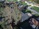 Aerial view of a property with lush green trees, a well-maintained lawn, and nearby amenities at 2063 De Carlo Ave, Spring Hill, FL 34608