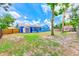 Sprawling backyard with a storage shed, mature trees, and a colorful blue house at 2063 De Carlo Ave, Spring Hill, FL 34608