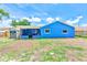 Backyard of blue home featuring a shed, screened in porch, and green and brown yard at 2063 De Carlo Ave, Spring Hill, FL 34608