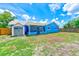 Bright blue single-story home with a screened-in porch, storage shed, and partial grass in the backyard at 2063 De Carlo Ave, Spring Hill, FL 34608