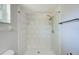 Tiled shower with updated showerhead, grab bar, and storage shelves at 2063 De Carlo Ave, Spring Hill, FL 34608